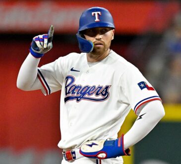 Texas Rangers right fielder Brandon Nimmo stands at second base and points one finger in the air.