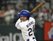 Texas Rangers right fielder Brandon Nimmo follows through on a swing with his bat raised over his shoulder.