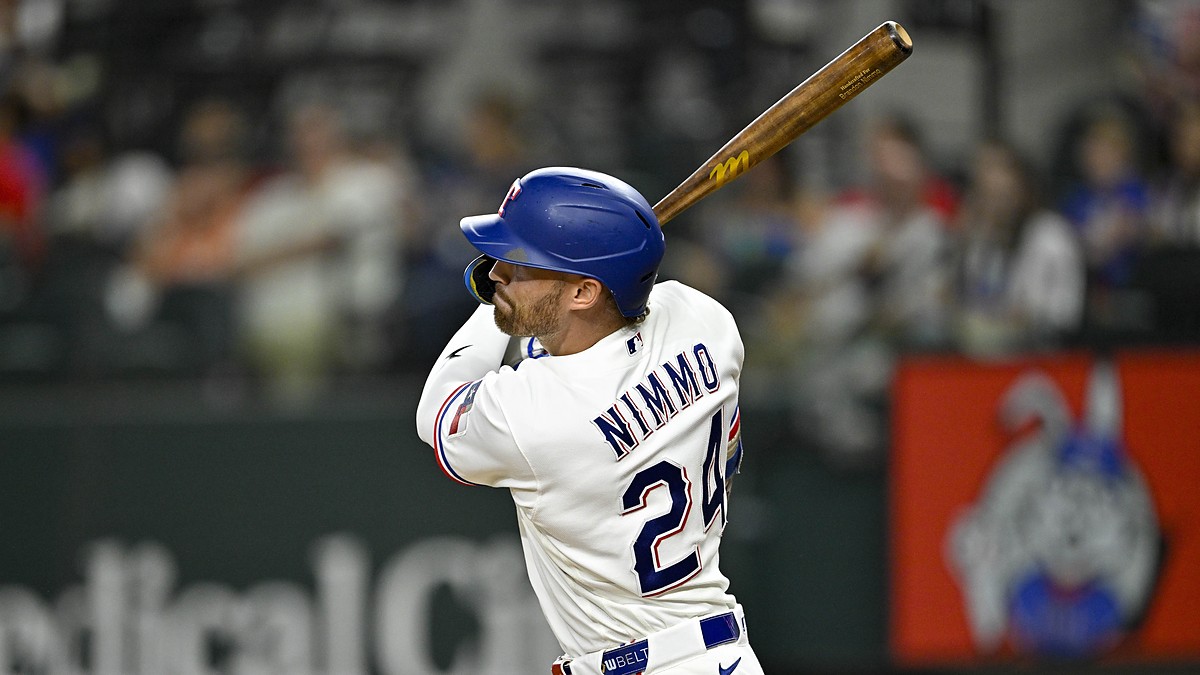 Texas Rangers right fielder Brandon Nimmo follows through on a swing with his bat raised over his shoulder.