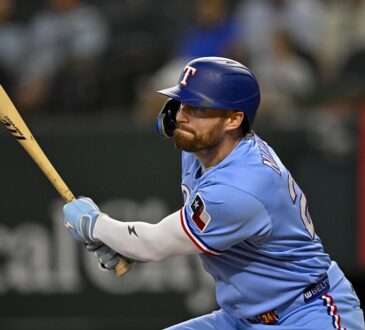 Texas Rangers right fielder Brandon Nimmo watches the ball after a swing in a powder blue Rangers uniform.