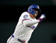 Texas Rangers center fielder Brandon Nimmo runs the bases in his home whites with his arms pumping.