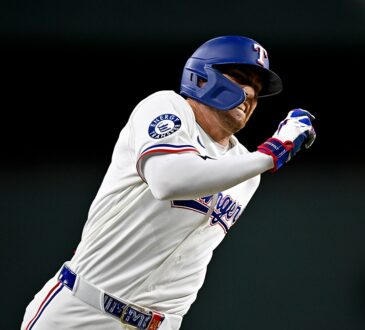 Texas Rangers center fielder Brandon Nimmo runs the bases in his home whites with his arms pumping.