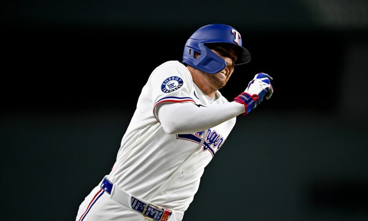 Texas Rangers center fielder Brandon Nimmo runs the bases in his home whites with his arms pumping.