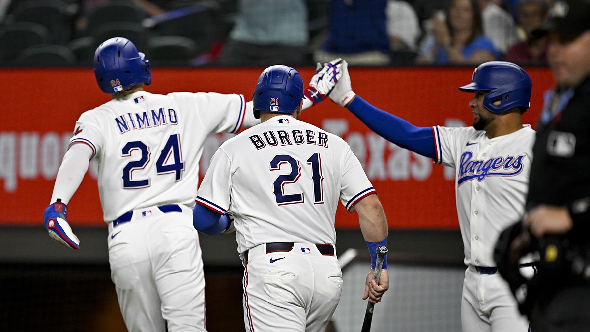 Rangers teammates Brandon Nimmo, Jake Burger, and Elias Díaz celebrate after a run scores.