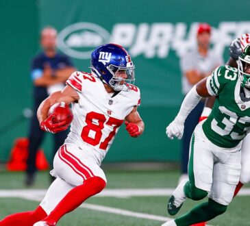 New York Giants wide receiver Braxton Berrios tucks the ball and cuts upfield as a New York Jets defender pursues.