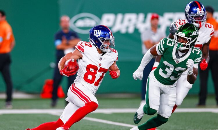 New York Giants wide receiver Braxton Berrios tucks the ball and cuts upfield as a New York Jets defender pursues.