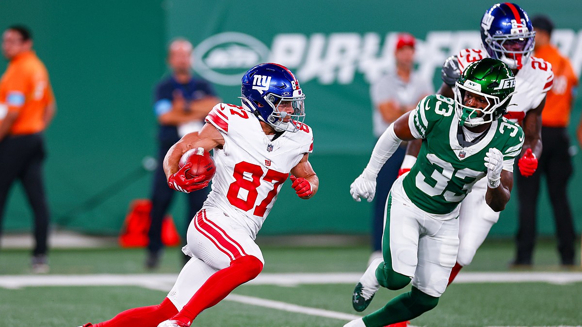 New York Giants wide receiver Braxton Berrios tucks the ball and cuts upfield as a New York Jets defender pursues.