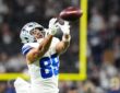 Dallas Cowboys tight end Brevyn Spann-Ford reaches out with both hands to catch a pass during warmups.