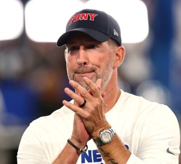 Dallas Cowboys head coach Brian Schottenheimer stands with his hands together watching pregame warmups.
