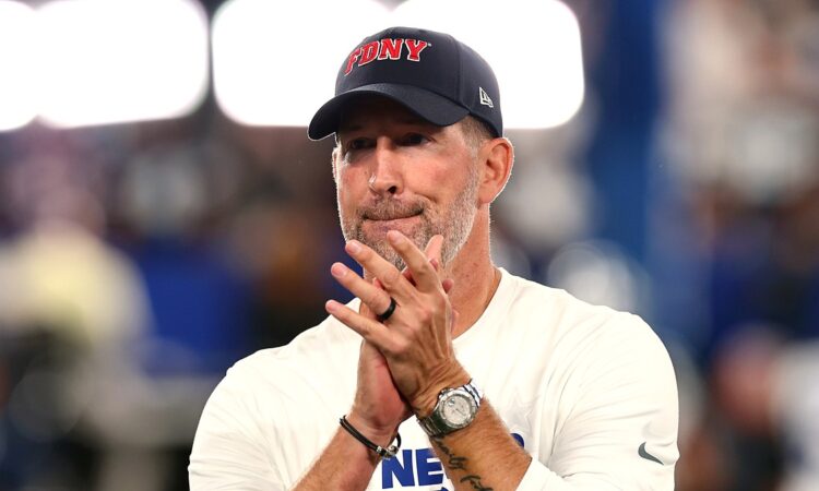 Dallas Cowboys head coach Brian Schottenheimer stands with his hands together watching pregame warmups.