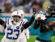 Jacksonville Jaguars wide receiver Brian Thomas Jr. hauls in a pass in the rain as Colts cornerback Kenny Moore II reaches.