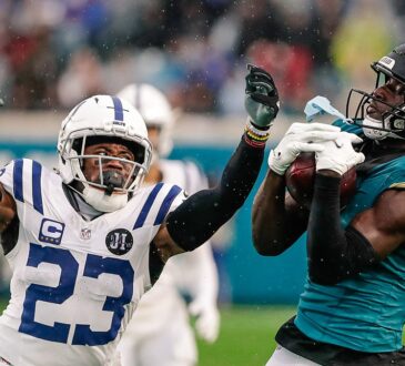 Jacksonville Jaguars wide receiver Brian Thomas Jr. hauls in a pass in the rain as Colts cornerback Kenny Moore II reaches.