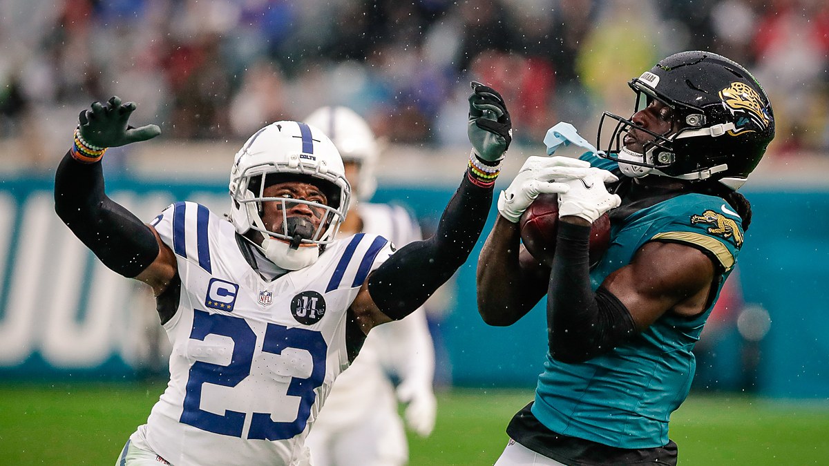 Jacksonville Jaguars wide receiver Brian Thomas Jr. hauls in a pass in the rain as Colts cornerback Kenny Moore II reaches.