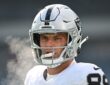 Las Vegas Raiders tight end Brock Bowers looks on in his helmet before a cold-weather game against the Eagles.