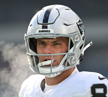 Las Vegas Raiders tight end Brock Bowers looks on in his helmet before a cold-weather game against the Eagles.