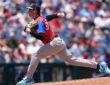 American League pitcher Caden Scarborough, No. 11, drives off the mound to deliver a pitch.