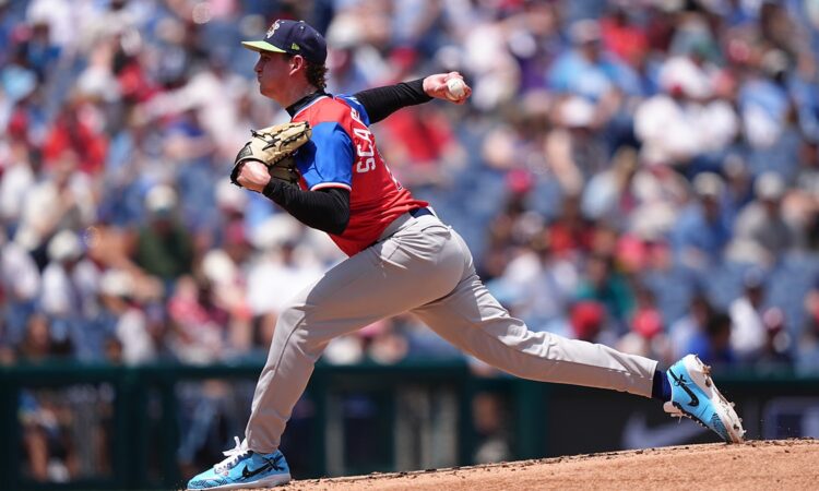 American League pitcher Caden Scarborough, No. 11, drives off the mound to deliver a pitch.