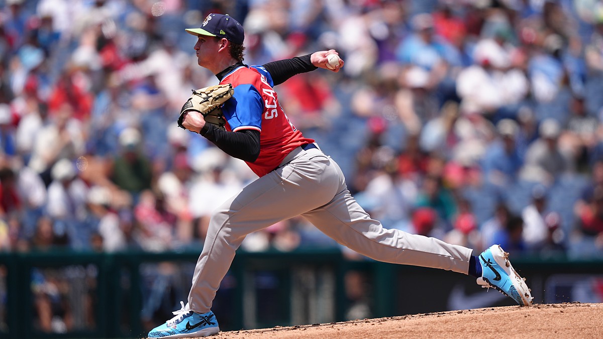 American League pitcher Caden Scarborough, No. 11, drives off the mound to deliver a pitch.