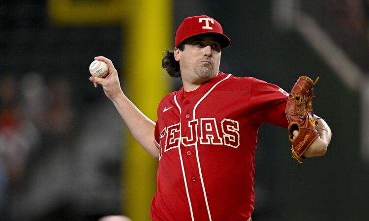 Texas Rangers pitcher Cal Quantrill, in a red Tejas jersey, rears back to throw a pitch.