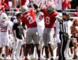 Ohio State Buckeyes safety Caleb Downs and linebacker Arvell Reese raise their arms in celebration near the Texas sideline.