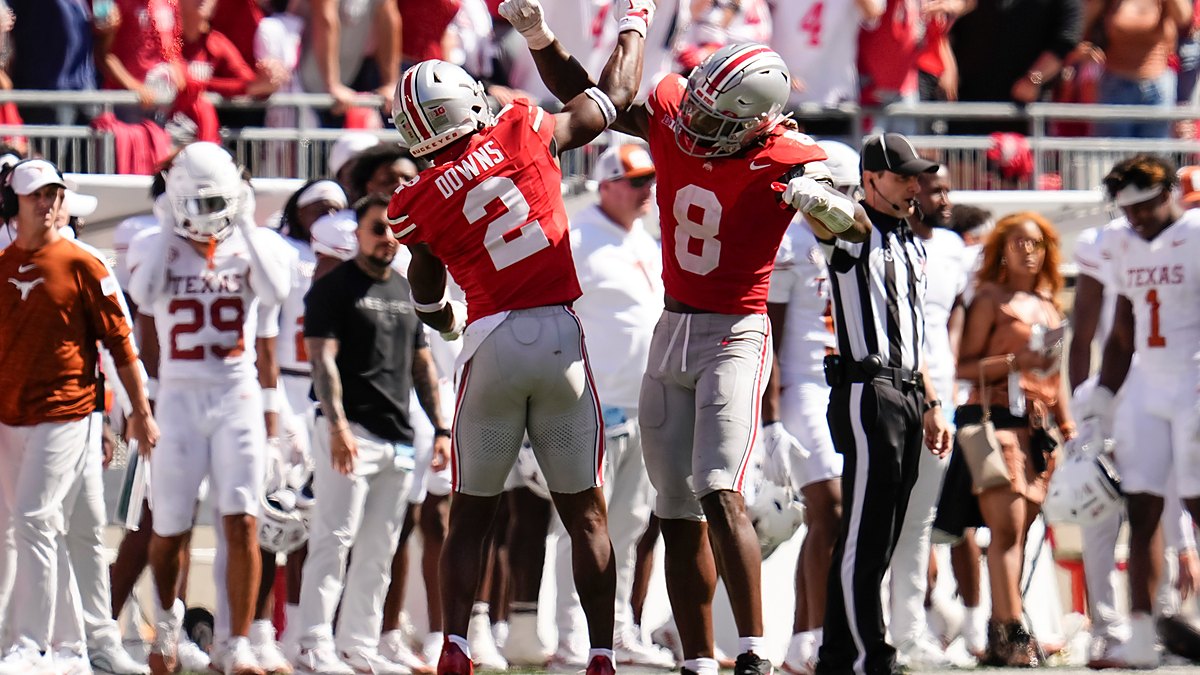 Ohio State Buckeyes safety Caleb Downs and linebacker Arvell Reese raise their arms in celebration near the Texas sideline.
