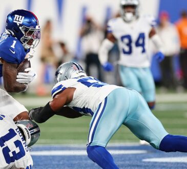 Two Dallas Cowboys defenders wrap up New York Giants wide receiver Malik Nabers after a catch.