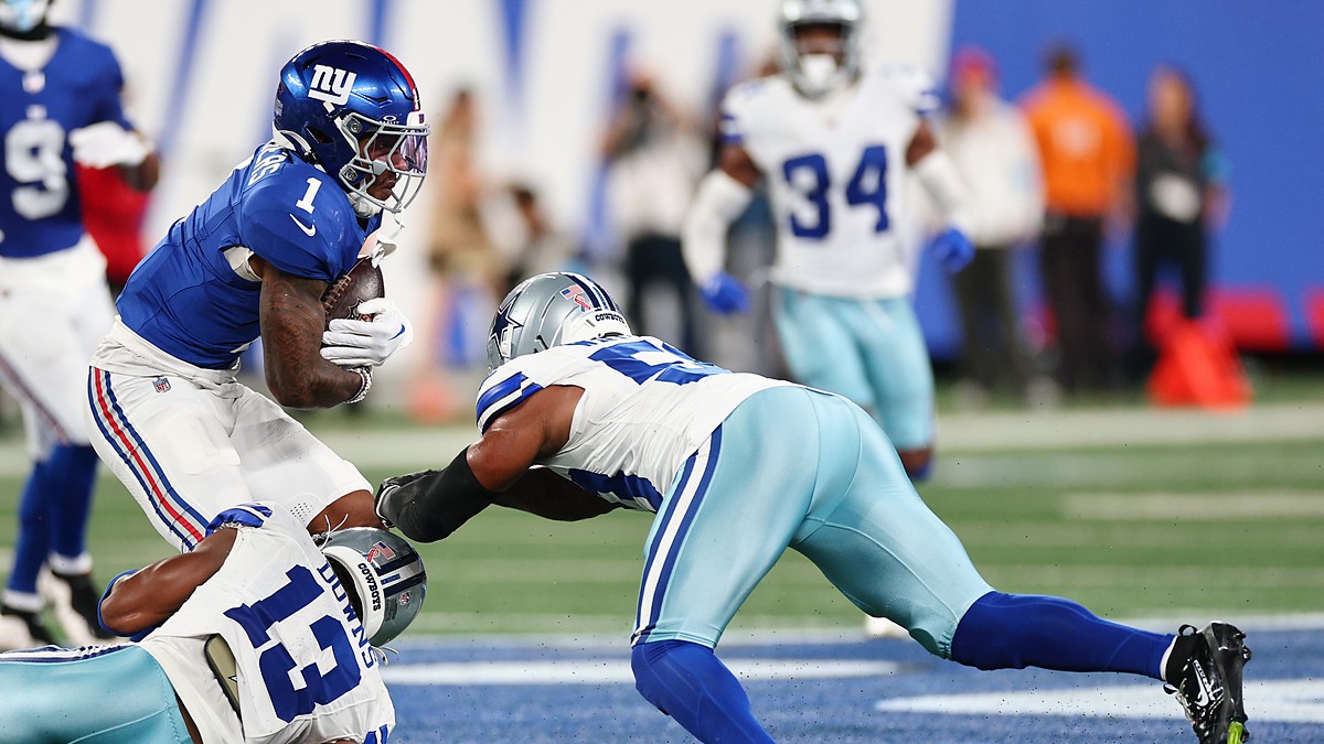 Two Dallas Cowboys defenders wrap up New York Giants wide receiver Malik Nabers after a catch.