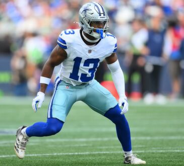Dallas Cowboys safety Caleb Downs settles into a wide defensive stance on the field.