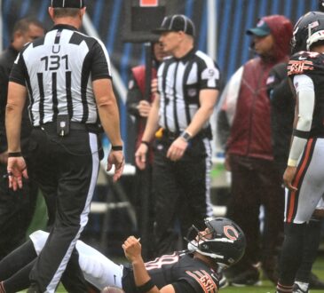 Chicago Bears quarterback Caleb Williams #18 lies on the field with an apparent injury against the Minnesota Vikings at Soldier Field.