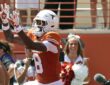 Texas Longhorns wide receiver Cam Coleman, No. 8, reaches up for a touchdown pass as the ball arrives.