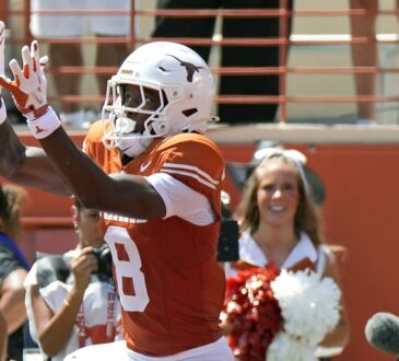 Texas Longhorns wide receiver Cam Coleman, No. 8, reaches up for a touchdown pass as the ball arrives.