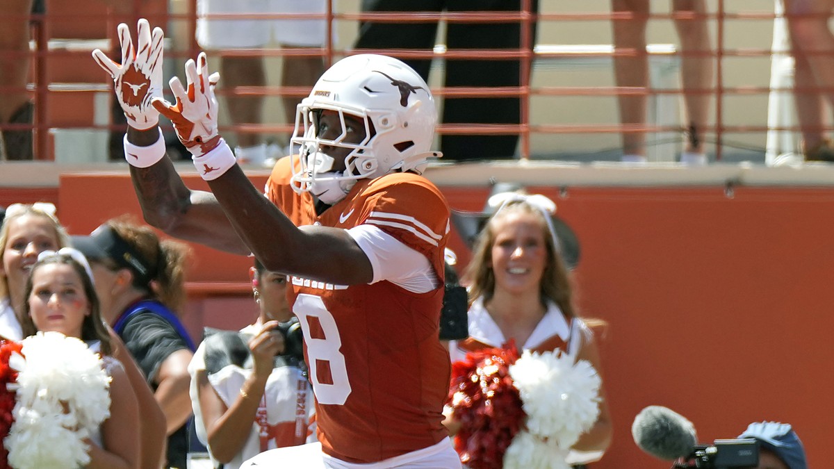 Texas Longhorns wide receiver Cam Coleman, No. 8, reaches up for a touchdown pass as the ball arrives.