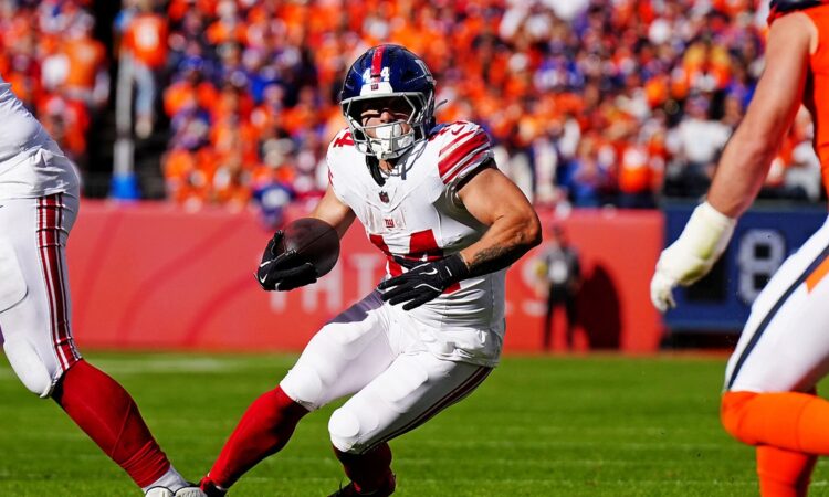 New York Giants running back Cam Skattebo, No. 44, plants and cuts with the ball in his left hand.