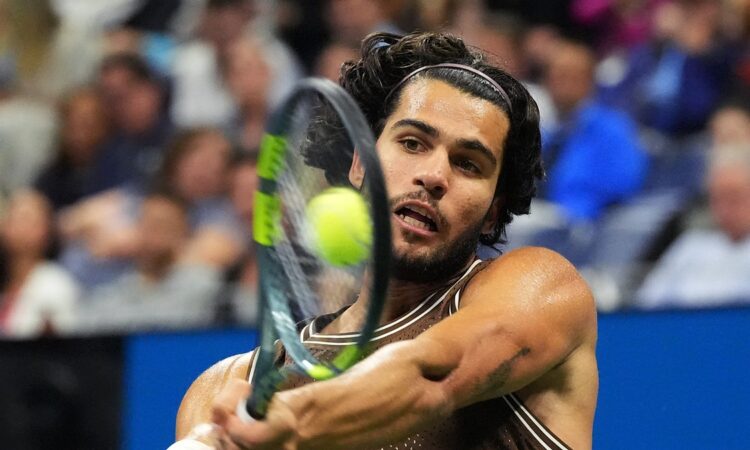 Spain's Carlos Alcaraz strikes a two-handed backhand during a night match at the U.S. Open.