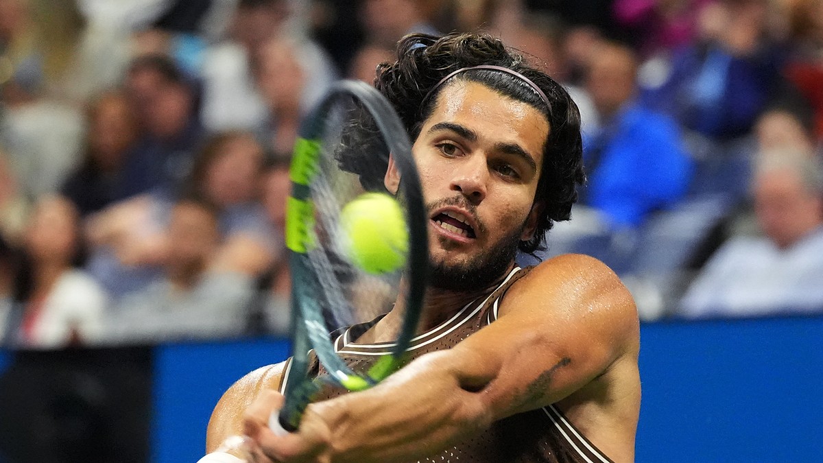 Spain's Carlos Alcaraz strikes a two-handed backhand during a night match at the U.S. Open.