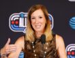 WNBA commissioner Cathy Engelbert speaks at a microphone in front of an All-Star backdrop.