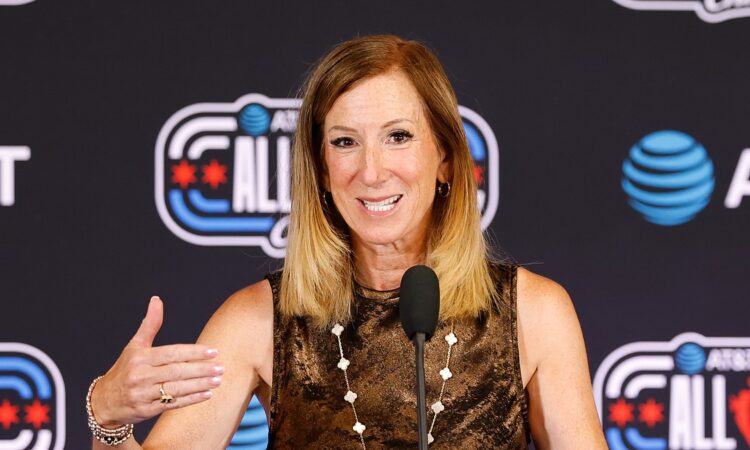 WNBA commissioner Cathy Engelbert speaks at a microphone in front of an All-Star backdrop.