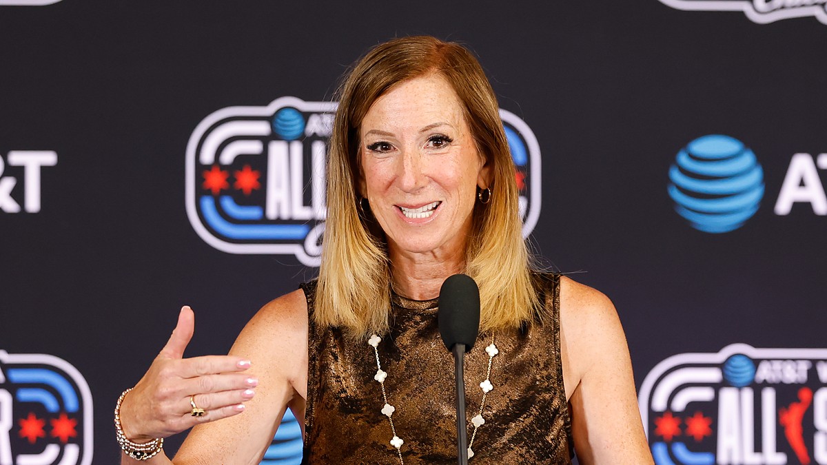 WNBA commissioner Cathy Engelbert speaks at a microphone in front of an All-Star backdrop.