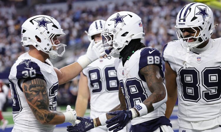 Dallas Cowboys wide receiver CeeDee Lamb shakes hands with teammates as they celebrate his touchdown catch in the end zone.