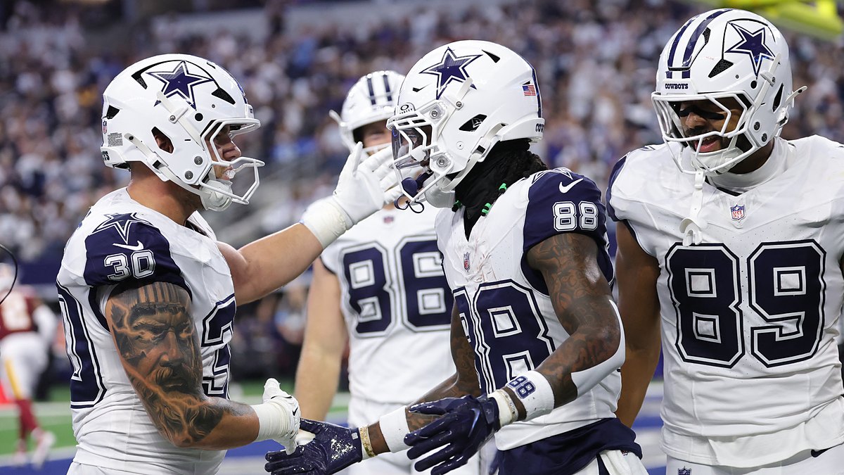 Dallas Cowboys wide receiver CeeDee Lamb shakes hands with teammates as they celebrate his touchdown catch in the end zone.