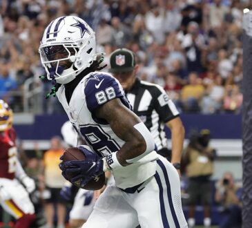 Cowboys wide receiver CeeDee Lamb clutches the football in the end zone after a touchdown catch.