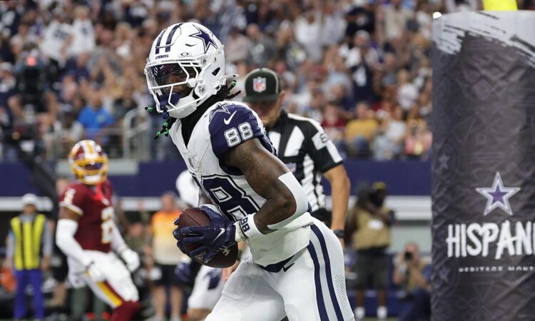 Cowboys wide receiver CeeDee Lamb clutches the football in the end zone after a touchdown catch.