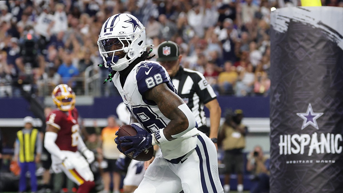 Cowboys wide receiver CeeDee Lamb clutches the football in the end zone after a touchdown catch.