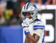 Dallas Cowboys wide receiver CeeDee Lamb raises a finger to his facemask as he reacts during a game against the Giants.