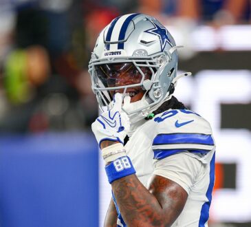 Dallas Cowboys wide receiver CeeDee Lamb raises a finger to his facemask as he reacts during a game against the Giants.