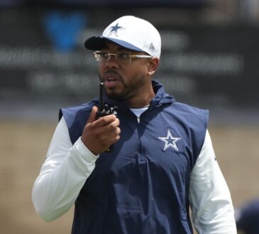 Dallas Cowboys defensive coordinator Christian Parker speaks into a radio during training camp practice.