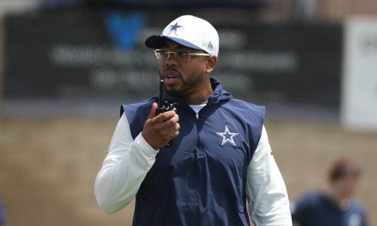 Dallas Cowboys defensive coordinator Christian Parker speaks into a radio during training camp practice.