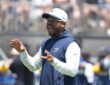 Cowboys defensive coordinator Christian Parker gestures with both hands as he calls out instructions at practice.