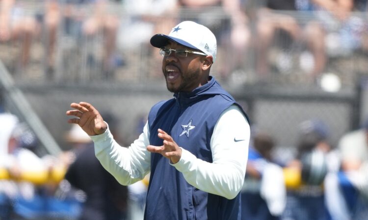 Cowboys defensive coordinator Christian Parker gestures with both hands as he calls out instructions at practice.