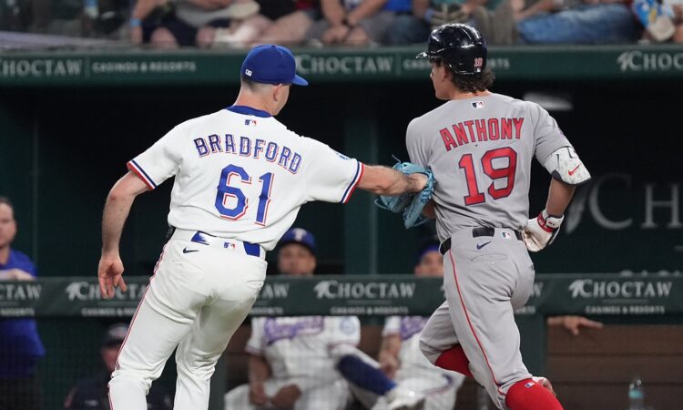 Texas Rangers pitcher Cody Bradford reaches out with his glove to tag Boston Red Sox runner Roman Anthony on the baseline.